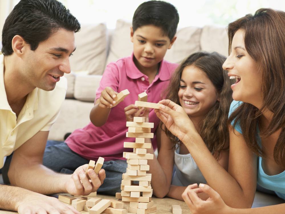 Family laughing together playing board game